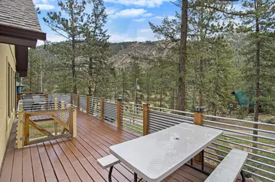 a wooden deck with a white table and benches on it at Cedar Ridge Sanctuary Rocky Mtn Natl Park in Lyons