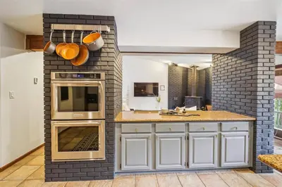 a kitchen with white cabinets and a brick wall at Pet-Friendly 3 Bedroom Townhome In Frisco - Short Drive To Breck! in Frisco