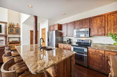 a kitchen with wooden cabinets and a granite counter top at Pet-Friendly 4 Bedroom Townhome In Frisco - Short Drive To Breck! in Frisco