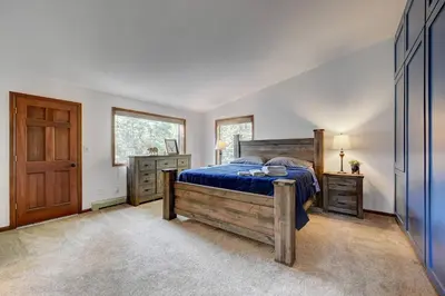a bedroom with a wooden bed and a wooden door at Evergreen Forest Retreat in Evergreen