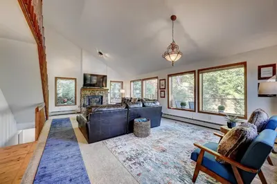 a living room with a couch and chairs and windows at Evergreen Forest Retreat in Evergreen
