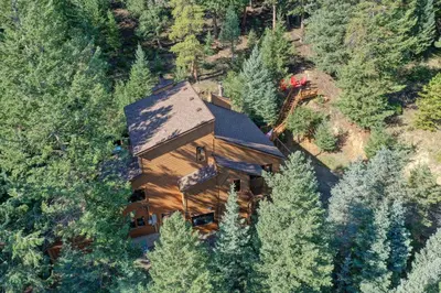 an overhead view of a large wooden house in the woods at Evergreen Forest Retreat in Evergreen