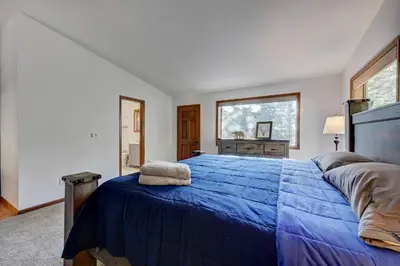 a bedroom with a blue bed and a window at Evergreen Forest Retreat in Evergreen