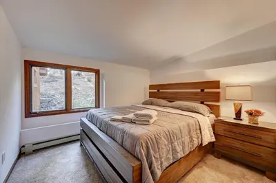 a bedroom with a large bed and a window at Evergreen Forest Retreat in Evergreen
