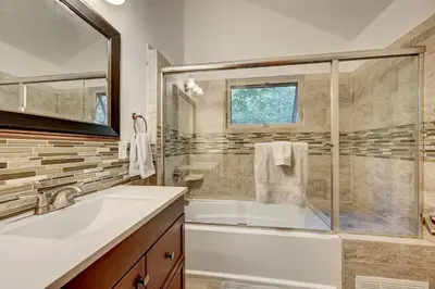 a bathroom with a tub and a sink and a shower at Evergreen Forest Retreat in Evergreen