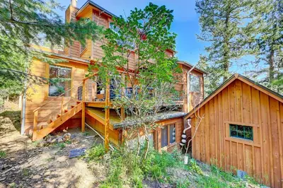 a log home with a staircase leading up to it at Evergreen Forest Retreat in Evergreen