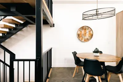 a dining room with a wooden table and black railings at New Modern Luxe Stay - Roof Deck - Center of RiNo in Denver