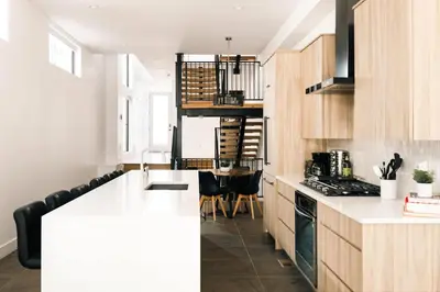a kitchen with wooden cabinets and a counter top at New Modern Luxe Stay - Roof Deck - Center of RiNo in Denver