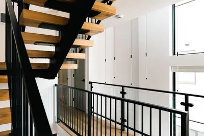 a staircase in a house with black railings at New Modern Luxe Stay - Roof Deck - Center of RiNo in Denver