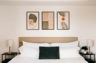 a bedroom with four pictures on the wall above a bed at New Modern Luxe Stay - Roof Deck - Center of RiNo in Denver