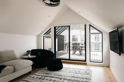 a living room with a couch and a large window at New Modern Luxe Stay - Roof Deck - Center of RiNo in Denver