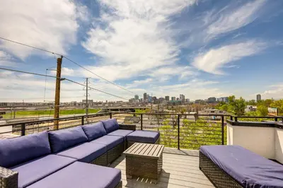 a balcony with a couch and a view of a city at 2 Mi to Ball Arena Townhome with Rooftop Patio in Denver