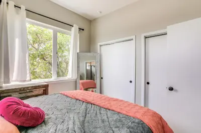 a bedroom with a bed with a heart pillow on it at 2 Mi to Ball Arena Townhome with Rooftop Patio in Denver
