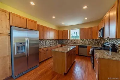 a kitchen with a stainless steel refrigerator and wooden cabinets at Mountain Retreat Near Grand Lake in Grand Lake