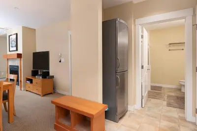 a kitchen with a stainless steel refrigerator and a table at Fraser Crossing 3227 Ski In Ski Out Winter Park Resort in Winter Park