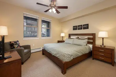 a bedroom with a bed and a couch and a ceiling fan at Fraser Crossing 3405 Ski In Ski Out Winter Park Resort in Winter Park