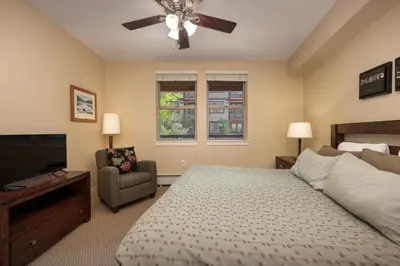 a bedroom with a bed and a television and a chair at Fraser Crossing 3405 Ski In Ski Out Winter Park Resort in Winter Park