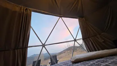a bedroom with a large window in a tent at The Nest at Black Hawk in Black Hawk