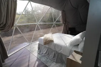 a bed in a tent with a large window at The Nest at Black Hawk in Black Hawk