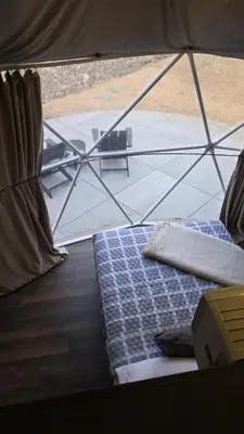 a bed in a tent with a view of a table at The Nest at Black Hawk in Black Hawk