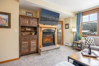 a living room with a fireplace with a flat screen tv at Zephyr Mountain Lodge 1420 Ski-In Ski-out Winter Park Resort base in Winter Park