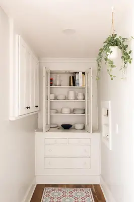 a white cabinet in a kitchen with a rug at Charming Highlands Cottage - Walk to Shops & Eats in Denver