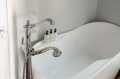 a white bath tub with a white toilet in a bathroom at Charming Highlands Cottage - Walk to Shops & Eats in Denver