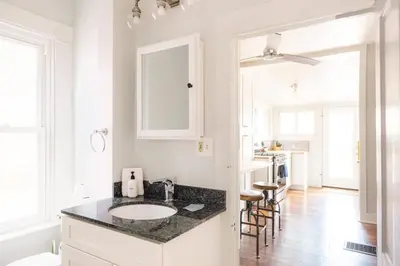 a white bathroom with a sink and a counter at Charming Highlands Cottage - Walk to Shops & Eats in Denver