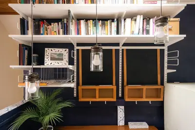 a room with two shelves with books and a plant at Charming Highlands Cottage - Walk to Shops & Eats in Denver