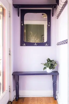 a bench in a room with a mirror and a plant at Charming Highlands Cottage - Walk to Shops & Eats in Denver