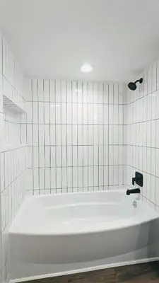 a white bath tub in a white tiled bathroom at Cozy Monthly 1BR Near NREL & Trails - Quaker Room 1 in Golden