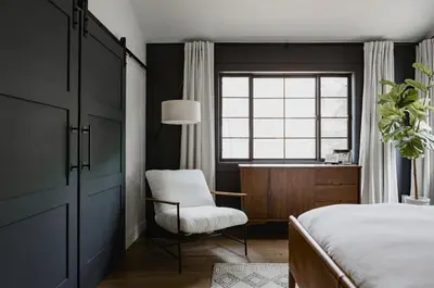 a bedroom with a bed and a chair and a window at Midtown Oasis in Fort Collins