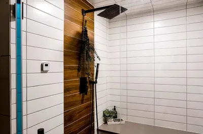 a pivot door in a bathroom with white tiles at Midtown Oasis in Fort Collins
