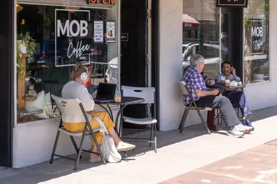 two people sitting at a table in front of a store at Quiet and Comfy Oasis - Firepit and Yard in Denver in Denver