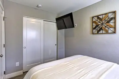 a bedroom with a white bed and a cabinet at Quiet and Comfy Oasis - Firepit and Yard in Denver in Denver