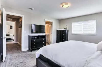 a bedroom with a bed and a flat screen tv at Spacious and Quiet Retreat - Firepit and Yard in Denver