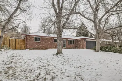 a brick house in a yard covered in snow at Cozy Monthly 1BR near NREL & trails - 7th room 2 in Golden