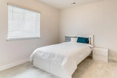 a white bedroom with a bed and a window at 12 Mi to Hospitals Modern Apartment in Aurora! in Aurora