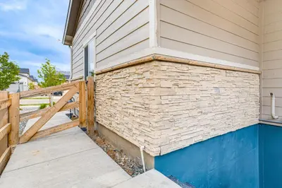 a house with a wooden fence on the side of it at 12 Mi to Hospitals Modern Apartment in Aurora! in Aurora