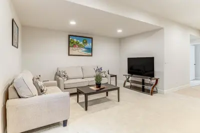 a living room with a couch and a tv at 12 Mi to Hospitals Modern Apartment in Aurora! in Aurora