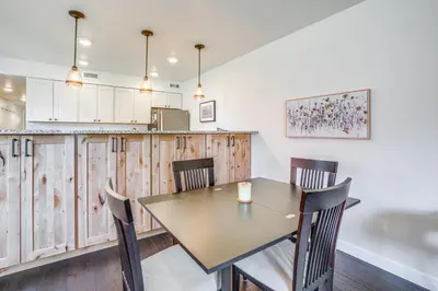 a kitchen with wooden cabinets and a table and chairs at half Mi to Dtwn Frisco Mtn-View Condo with Pool! in Frisco