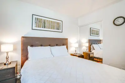 a bedroom with a white bed and a clock on the wall at half Mi to Dtwn Frisco Mtn-View Condo with Pool! in Frisco