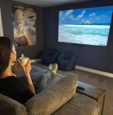 a woman sitting on a couch with a cup of coffee at Mid Summer Night's Dream w/HotTub&Theater in Arvada