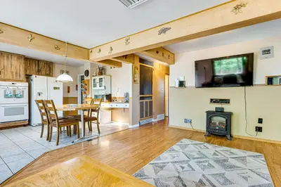 a kitchen and living room with a table and a fireplace at Near Family-Friendly Attractions Northglenn Home! in Northglenn
