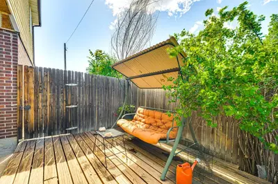 an orange couch sitting under an umbrella on a deck at Near Family-Friendly Attractions Northglenn Home! in Northglenn