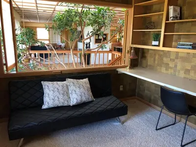 a black couch sitting in a room with plants at Unique Home 40 acres Peaceful Near Boulder 2 Dogs OK in Longmont