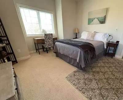a bedroom with a bed and a desk and a window at A Peaceful Slice of Heaven Near Boulder in Niwot