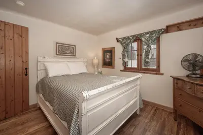 a bedroom with a white bed and a window at West Portal Cabin cabin in Grand Lake