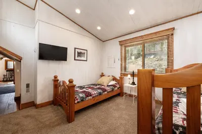 a bedroom with a bed and a tv on the wall at West Portal Cabin cabin in Grand Lake