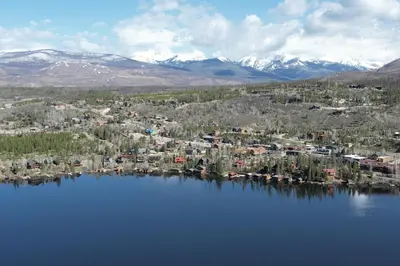 an aerial view of a lake with houses and mountains at West Portal Cabin cabin in Grand Lake